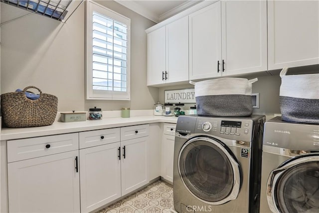 clothes washing area with cabinet space, ornamental molding, and washing machine and clothes dryer