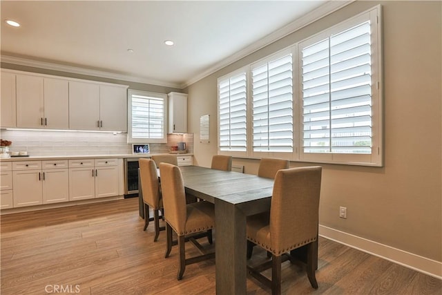 2454 Nova Way, Corona, CA 92883 - dining space featuring crown molding, light wood-style floors, wine cooler, recessed lighting, and baseboards
