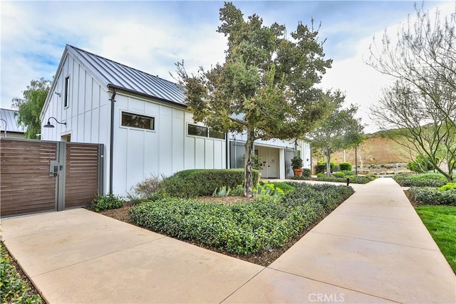 view of front of home with a standing seam roof, a gate, board and batten siding, and metal roof