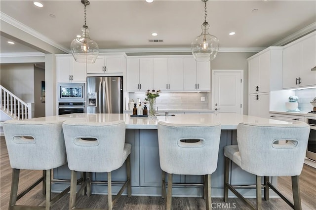 kitchen featuring backsplash, a large island, visible vents, stainless steel appliances, and white cabinetry