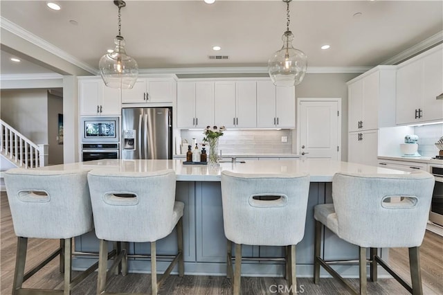 2454 Nova Way, Corona, CA 92883 - kitchen featuring stainless steel appliances, decorative backsplash, a spacious island, wood finished floors, and recessed lighting