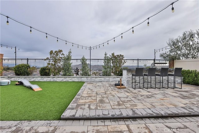 view of patio / terrace featuring fence and outdoor dry bar