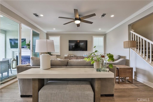 living area with visible vents, a ceiling fan, and plenty of natural light