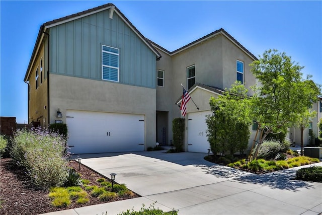 2454 Nova Way, Corona, CA 92883 - view of front of house featuring board and batten siding, an attached garage, driveway, and stucco siding