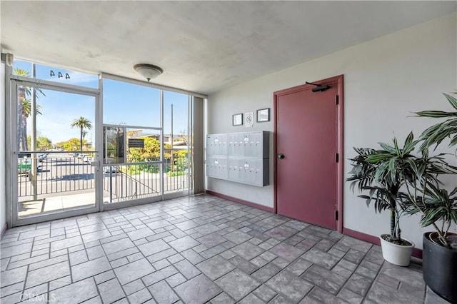 444 Obispo Ave Unit 201, Long Beach, CA 90814 - empty room featuring mail area, healthy amount of natural light, baseboards, expansive windows, and stone finish floors