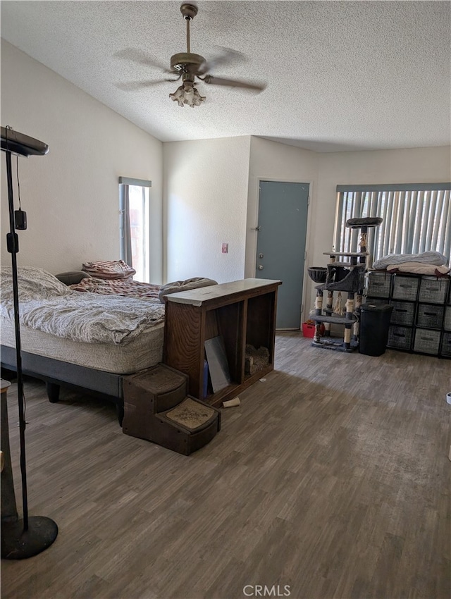 bedroom with ceiling fan, a textured ceiling, and wood finished floors