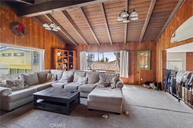 living area with wooden walls, vaulted ceiling with beams, and a wealth of natural light
