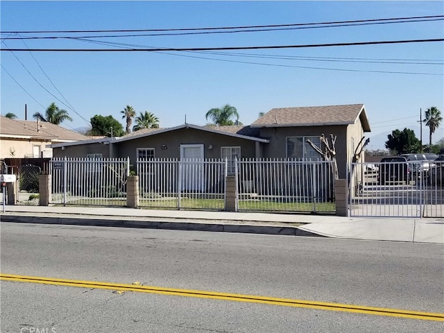 view of front of house featuring a fenced front yard, a gate, and stucco siding