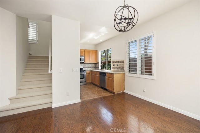 8 Carey Ct, Aliso Viejo, CA 92656 - kitchen featuring a notable chandelier, light countertops, baseboards, appliances with stainless steel finishes, and dark wood-style flooring