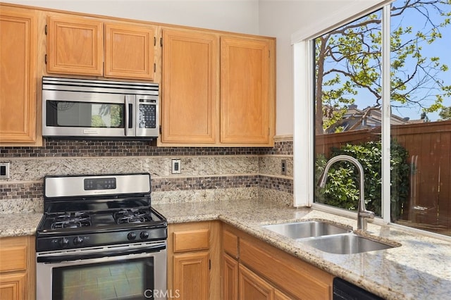 8 Carey Ct, Aliso Viejo, CA 92656 - kitchen with light stone counters, a sink, appliances with stainless steel finishes, and tasteful backsplash