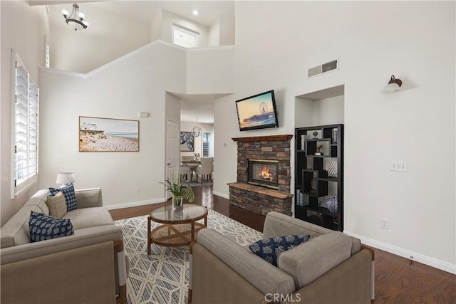 8 Carey Ct, Aliso Viejo, CA 92656 - living room featuring a towering ceiling, wood finished floors, visible vents, a stone fireplace, and baseboards