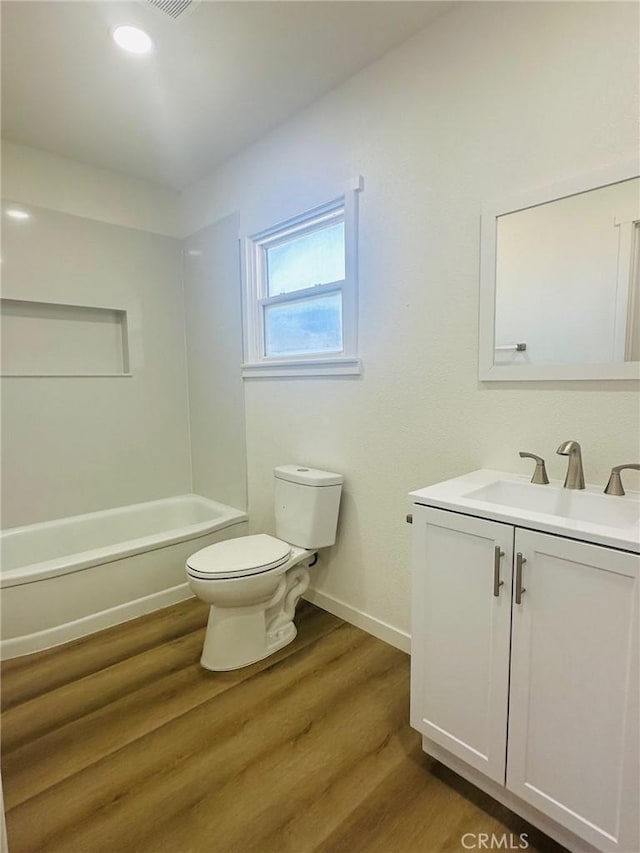full bath featuring vanity, baseboards, toilet, bathtub / shower combination, and wood finished floors