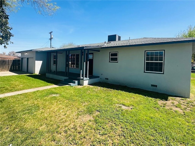 rear view of house with stucco siding, crawl space, an attached garage, a yard, and fence