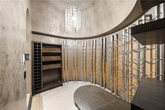 9 Shoreridge, Newport Coast, CA 92657 - wine room featuring built in shelves, a notable chandelier, and a towering ceiling