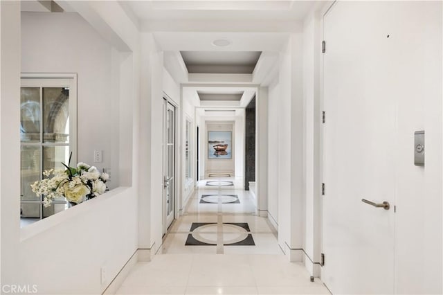 9 Shoreridge, Newport Coast, CA 92657 - hallway featuring a tray ceiling, light tile patterned floors, and baseboards