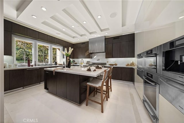 9 Shoreridge, Newport Coast, CA 92657 - kitchen with oven, modern cabinets, light countertops, dark brown cabinetry, and a breakfast bar area