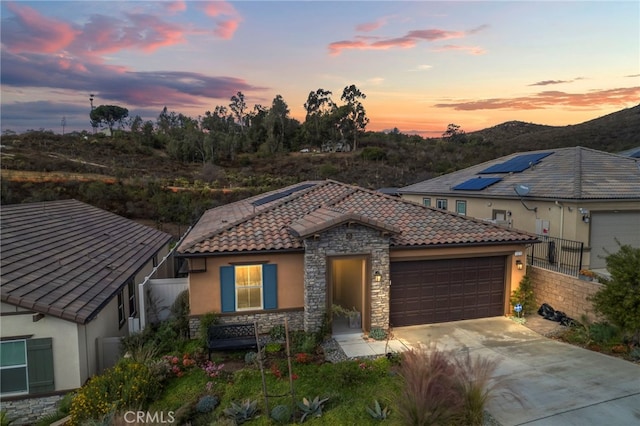 1373 Topanga Dr, San Marcos, CA 92069 - mediterranean / spanish-style house featuring stucco siding, stone siding, a garage, driveway, and a tiled roof
