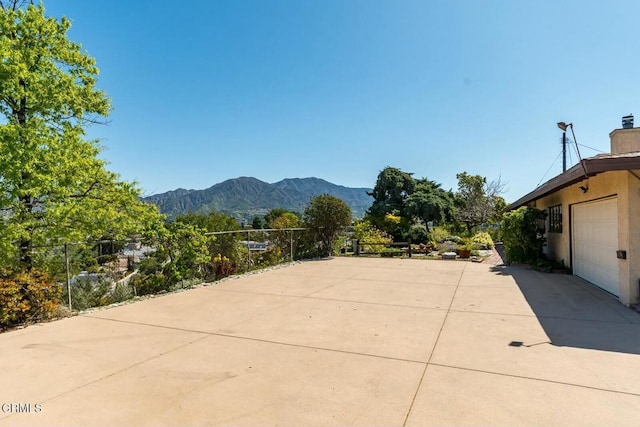 view of patio featuring a mountain view and fence