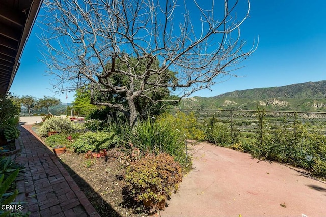 view of yard featuring a mountain view and fence