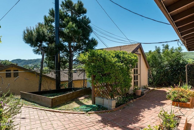 view of property exterior with an outbuilding, a garden, and fence