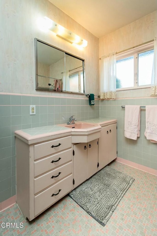 full bath featuring tile walls and vanity