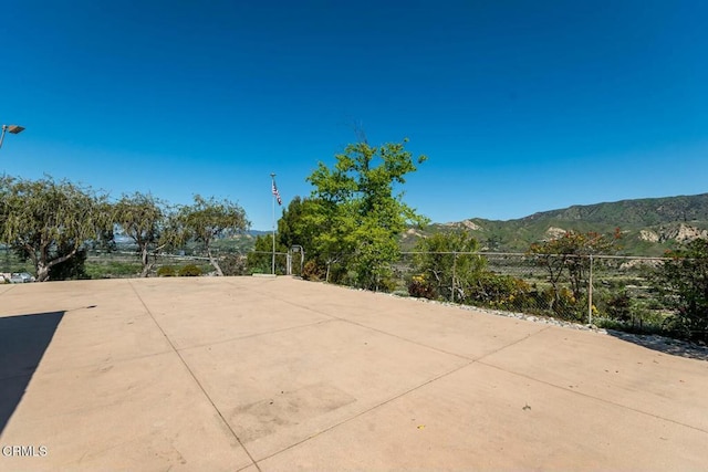 view of patio with fence and a mountain view