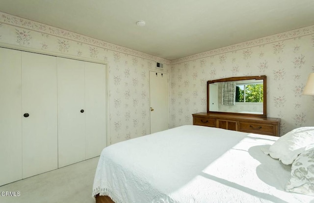 carpeted bedroom featuring a closet and visible vents