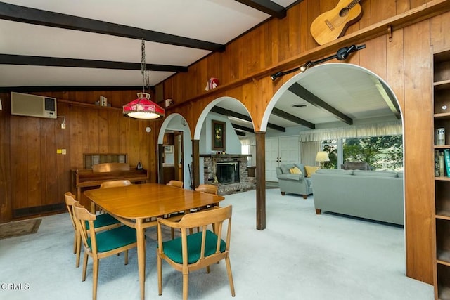 dining area with a wall mounted air conditioner, beamed ceiling, a fireplace, and wooden walls