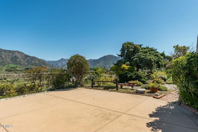view of patio / terrace featuring a mountain view and fence