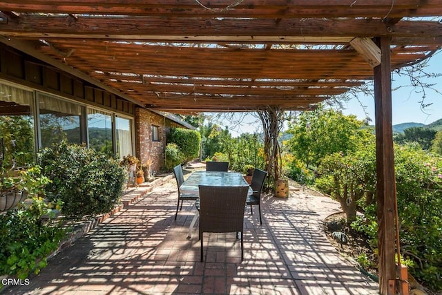 view of patio / terrace featuring a mountain view and outdoor dining area