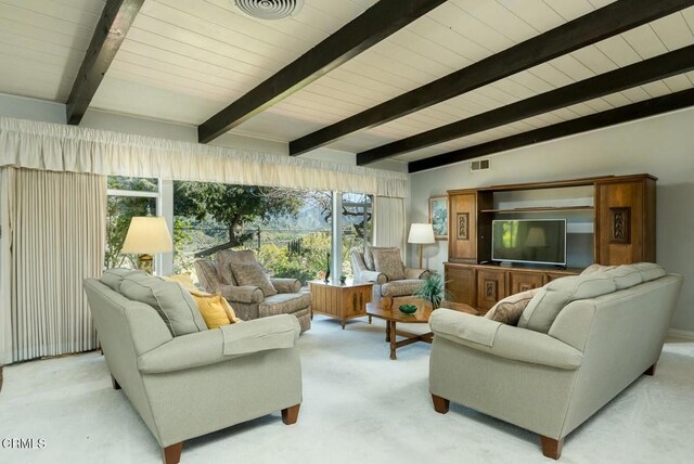 living area with visible vents, wooden ceiling, light colored carpet, and lofted ceiling with beams