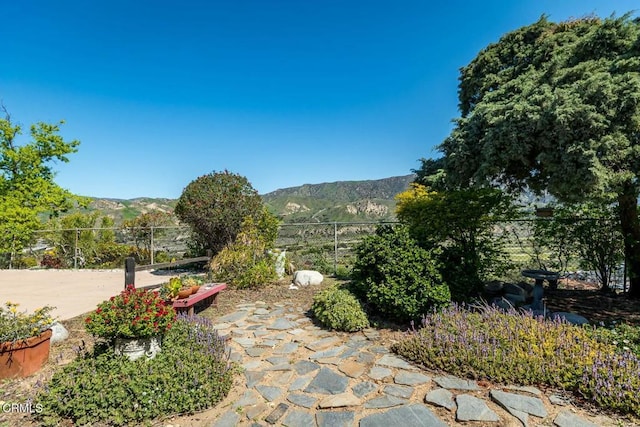 view of patio / terrace featuring a mountain view and fence