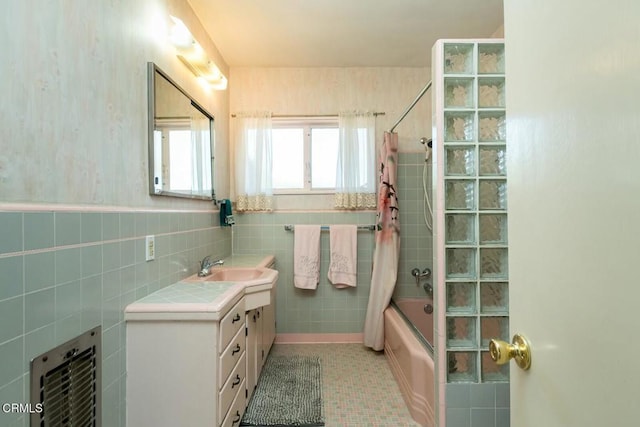bathroom with shower / tub combo with curtain, vanity, tile walls, and heating unit