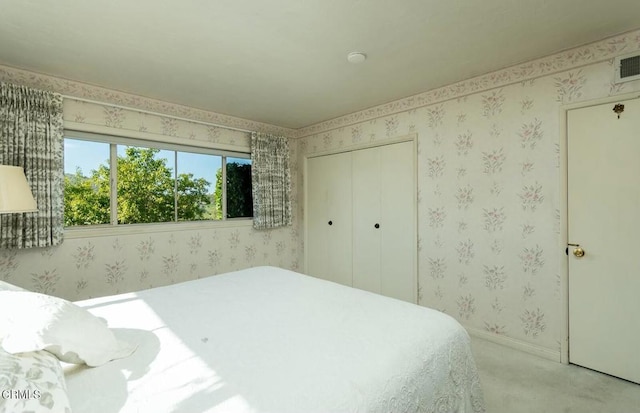 carpeted bedroom with a closet and baseboards