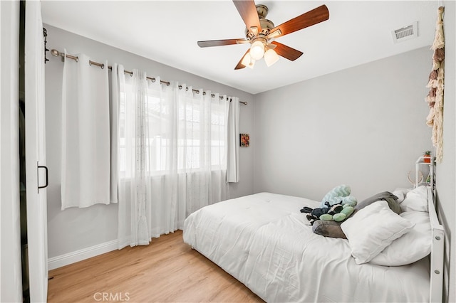bedroom with wood finished floors, baseboards, and a ceiling fan