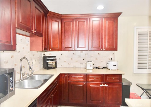 11792 Seacrest Dr, Garden Grove, CA 92840 - kitchen with dark brown cabinets, a sink, light countertops, decorative backsplash, and stainless steel microwave