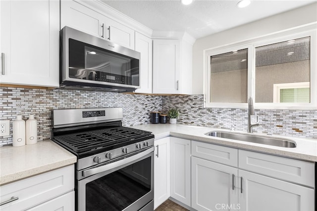 3012 W Oceanfront, Newport Beach, CA 92663 - kitchen with stainless steel appliances, a sink, white cabinets, decorative backsplash, and light stone counters