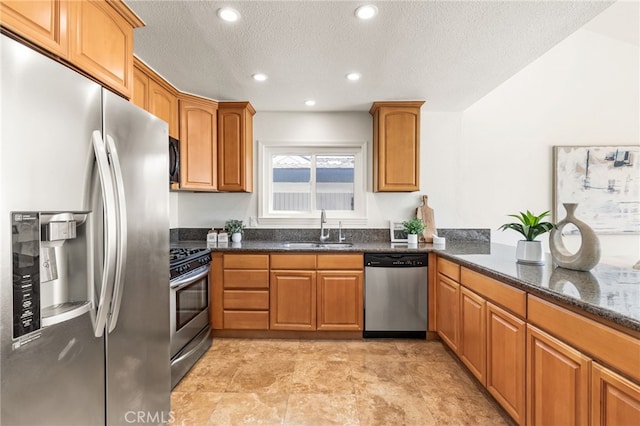 3012 W Oceanfront, Newport Beach, CA 92663 - kitchen with stainless steel appliances, a sink, dark stone countertops, brown cabinets, and a textured ceiling