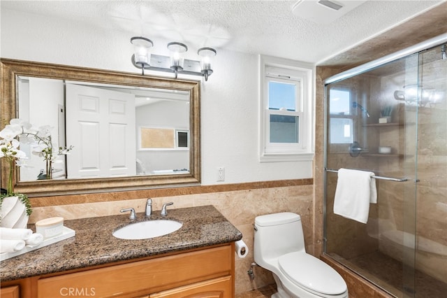3012 W Oceanfront, Newport Beach, CA 92663 - bathroom with tile walls, a textured ceiling, toilet, a stall shower, and vanity