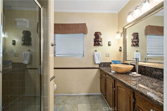 bathroom with vanity, baseboards, ornamental molding, toilet, and a shower stall