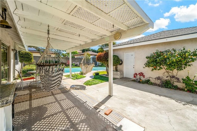 view of patio featuring an outdoor pool and fence
