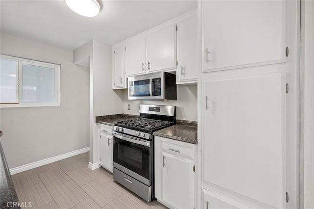 15021 Eureka St, Lake Elsinore, CA 92530 - kitchen with stainless steel appliances, dark countertops, white cabinets, and baseboards