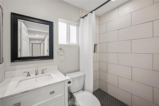 full bath with toilet, tiled shower, and vanity