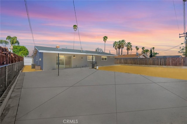 rear view of property featuring a patio, a fenced backyard, and stucco siding