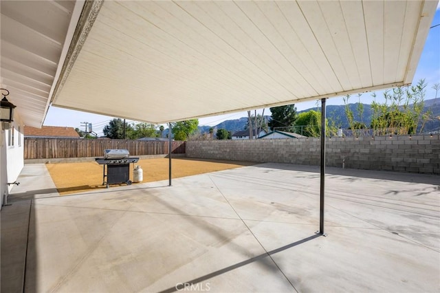 view of patio / terrace featuring a grill, a mountain view, and a fenced backyard