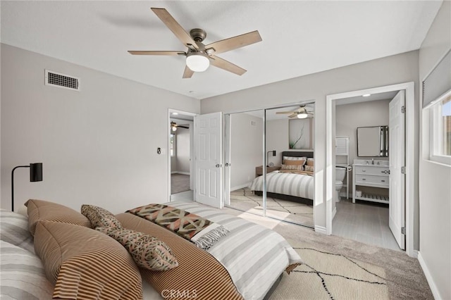 bedroom with ceiling fan, a closet, visible vents, light carpet, and baseboards