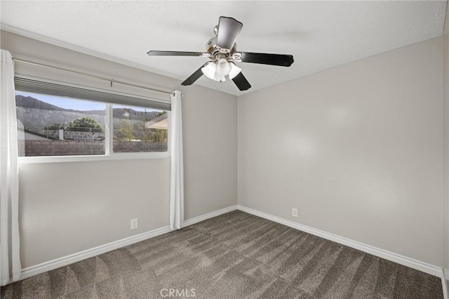 empty room featuring carpet, baseboards, and a ceiling fan