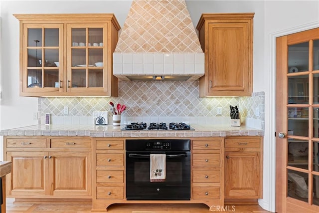 29083 Mammoth Dr, Lake Arrowhead, CA 92352 - kitchen with black oven, premium range hood, gas stovetop, and tasteful backsplash
