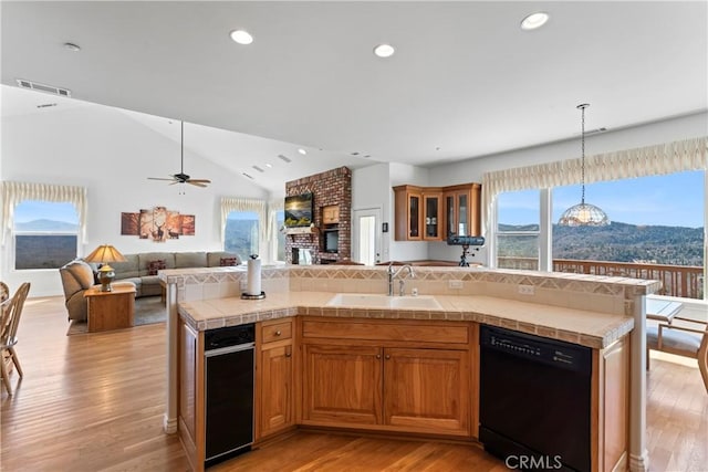 29083 Mammoth Dr, Lake Arrowhead, CA 92352 - kitchen featuring black dishwasher, open floor plan, light wood-type flooring, tile counters, and vaulted ceiling