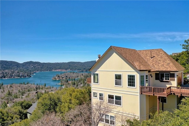 29083 Mammoth Dr, Lake Arrowhead, CA 92352 - back of property featuring a water and mountain view, a wooded view, and a shingled roof
